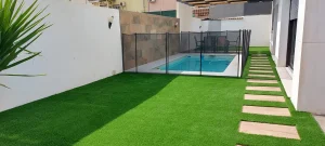 Césped para piscinas 33 Modelo-TERRANOVA-adosado-con-piscin-y-camino-baldosas-14